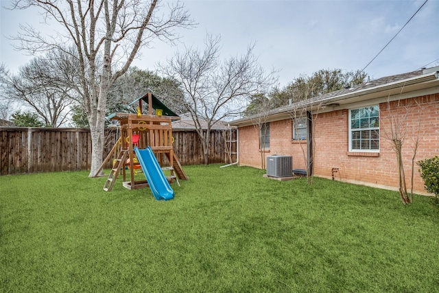 view of playground featuring a yard, central AC, and a fenced backyard