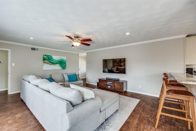 living room with a ceiling fan, dark wood-type flooring, crown molding, and visible vents