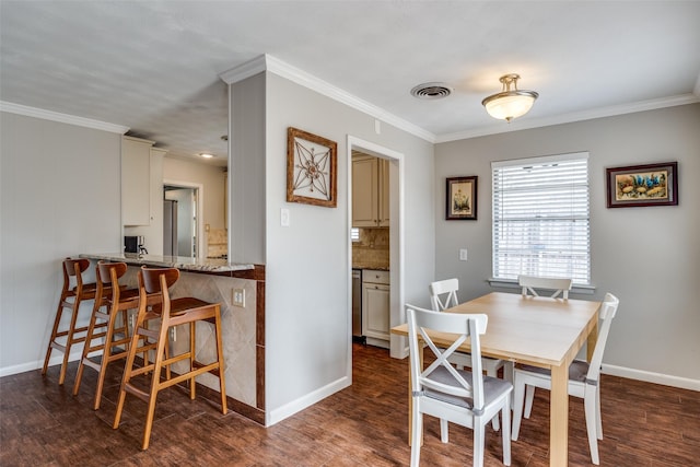 dining room with visible vents, baseboards, dark wood finished floors, and ornamental molding