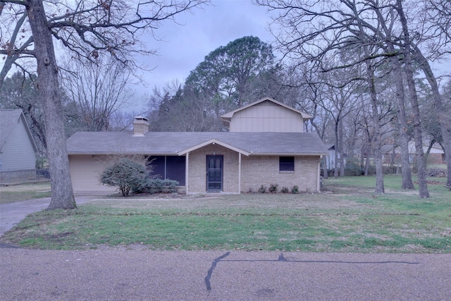 view of front of house featuring brick siding, a chimney, a shingled roof, and a front yard