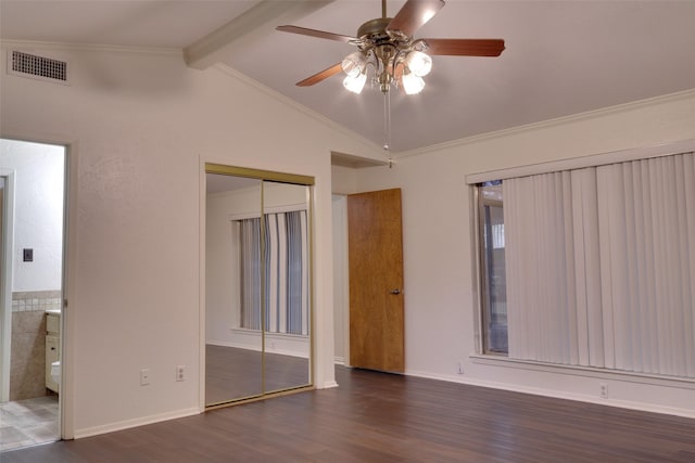 unfurnished bedroom featuring visible vents, crown molding, lofted ceiling with beams, wood finished floors, and a closet