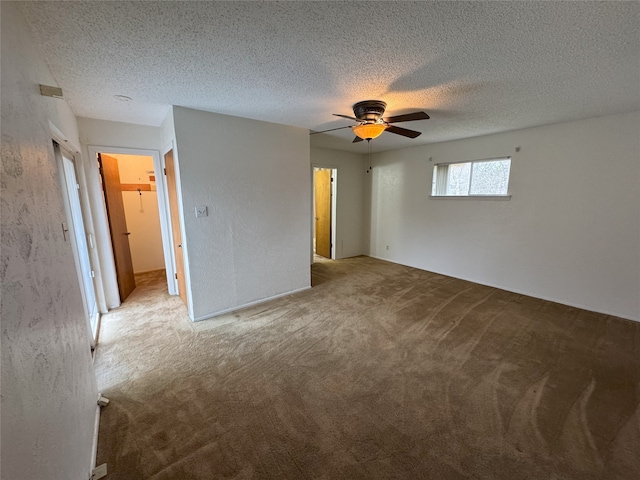 unfurnished bedroom with carpet floors, a textured ceiling, and a ceiling fan