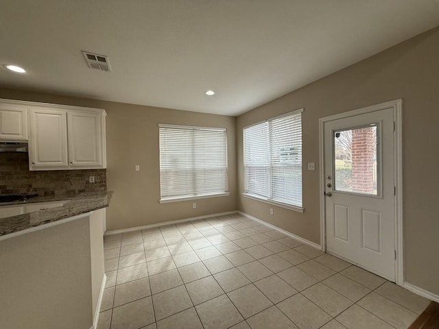 unfurnished dining area with light tile patterned floors, visible vents, recessed lighting, and baseboards