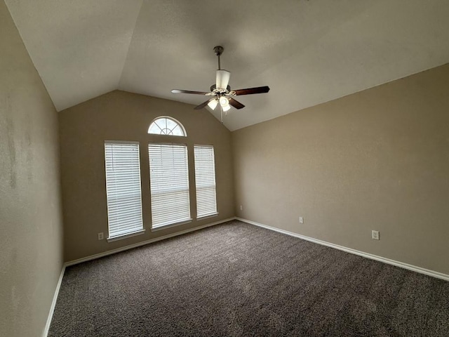 empty room featuring lofted ceiling, carpet flooring, a ceiling fan, and baseboards