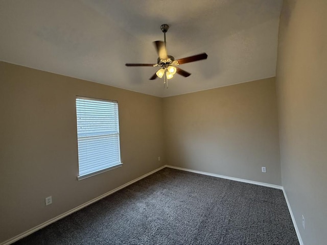 empty room with a ceiling fan, baseboards, and dark colored carpet