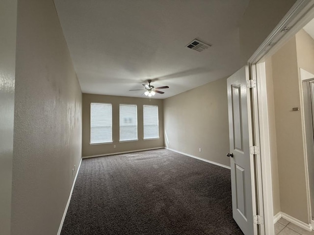 empty room featuring visible vents, baseboards, ceiling fan, and carpet flooring