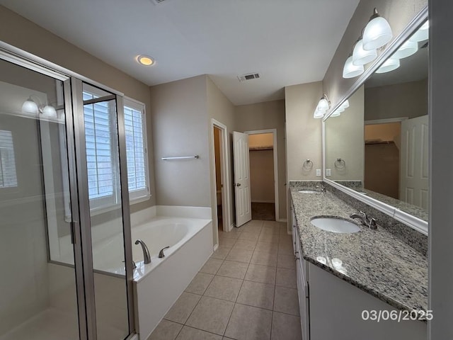 full bathroom with tile patterned floors, visible vents, a garden tub, a sink, and double vanity