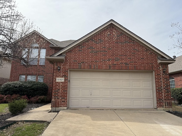 view of front of property featuring concrete driveway, a garage, and brick siding