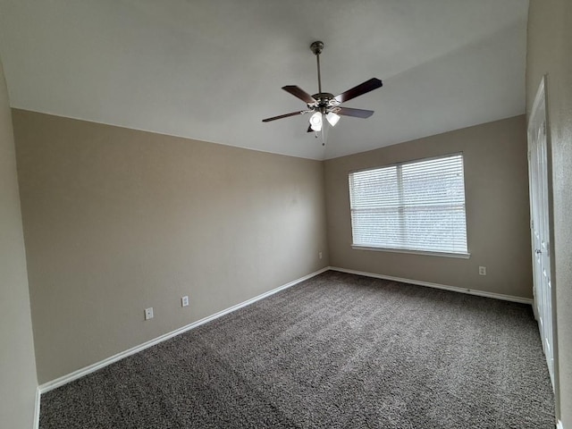 carpeted empty room featuring ceiling fan, baseboards, and lofted ceiling