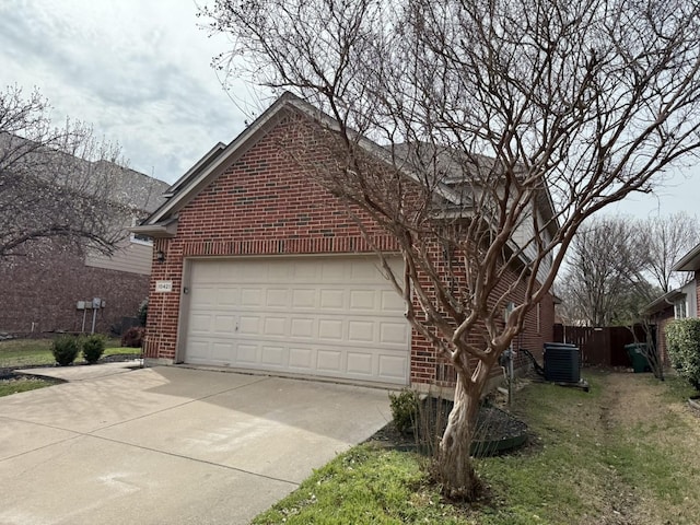 view of side of home with brick siding, cooling unit, concrete driveway, and a garage