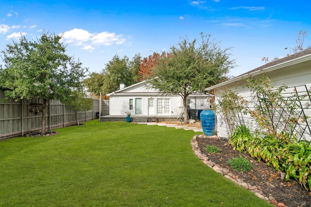 view of yard featuring fence and french doors