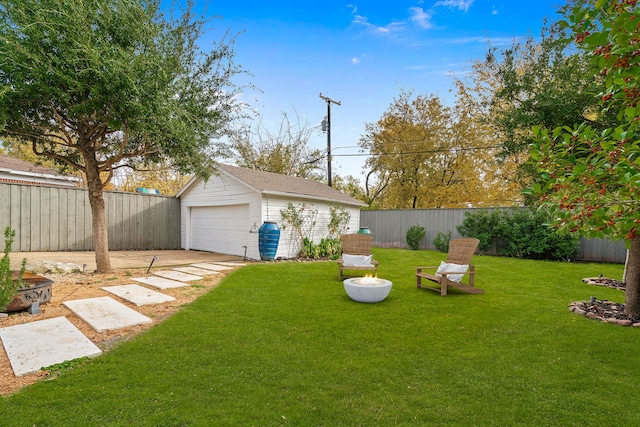 view of yard with a garage, a fenced backyard, an outdoor structure, and concrete driveway