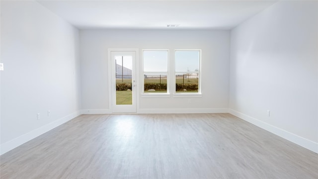 unfurnished room featuring baseboards, visible vents, and light wood-type flooring