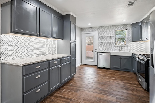 kitchen with visible vents, gray cabinets, dark wood-style floors, stainless steel appliances, and a sink