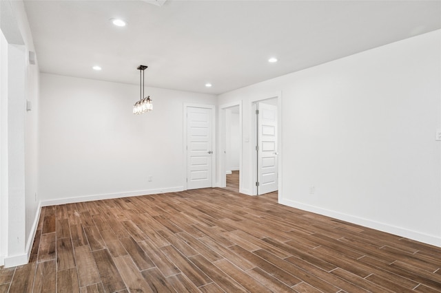 empty room featuring recessed lighting, baseboards, and dark wood finished floors