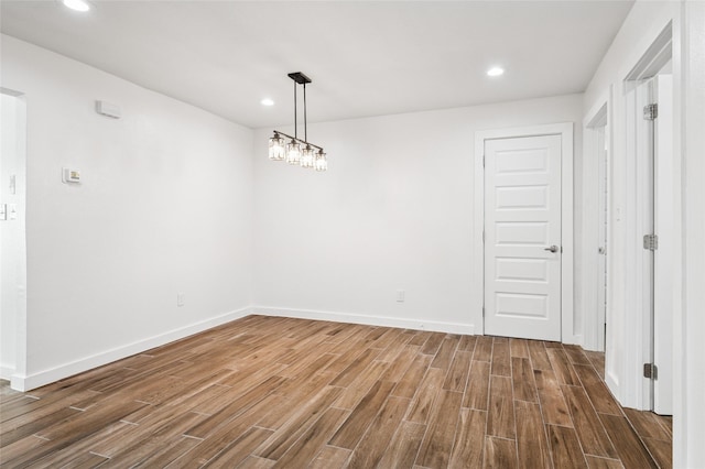 unfurnished dining area featuring recessed lighting, baseboards, and wood finished floors