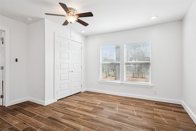 unfurnished bedroom featuring a closet, dark wood-type flooring, and baseboards