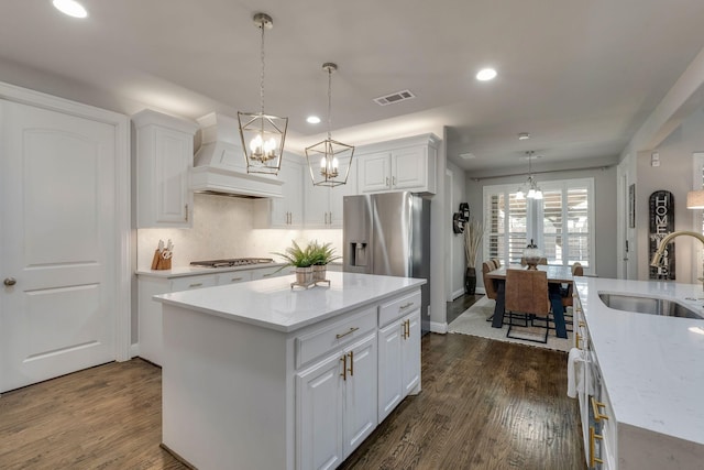 kitchen featuring visible vents, dark wood finished floors, an inviting chandelier, custom exhaust hood, and a sink