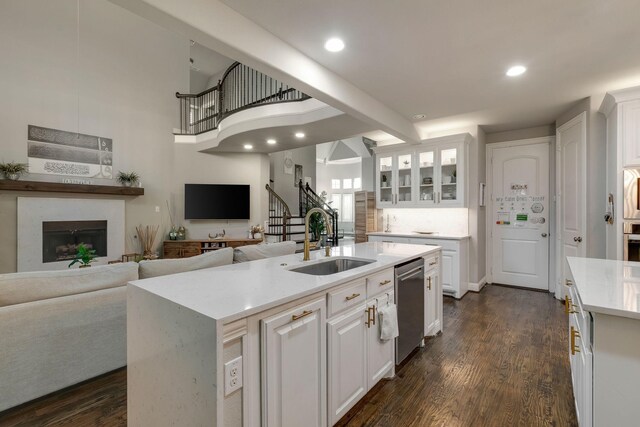 kitchen with open floor plan, appliances with stainless steel finishes, white cabinetry, and a sink