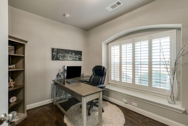 home office with wood finished floors, visible vents, and baseboards