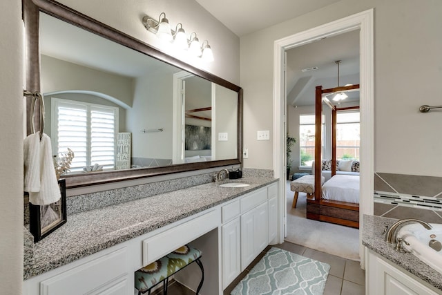 bathroom with tile patterned floors, plenty of natural light, ensuite bath, and a bath