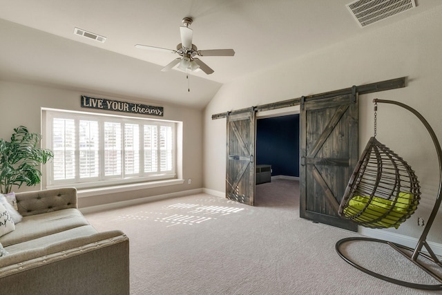 sitting room with a barn door, baseboards, visible vents, and lofted ceiling