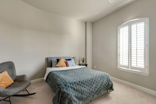 bedroom featuring visible vents, baseboards, and light carpet