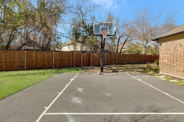 view of basketball court with a lawn, basketball court, and a fenced backyard