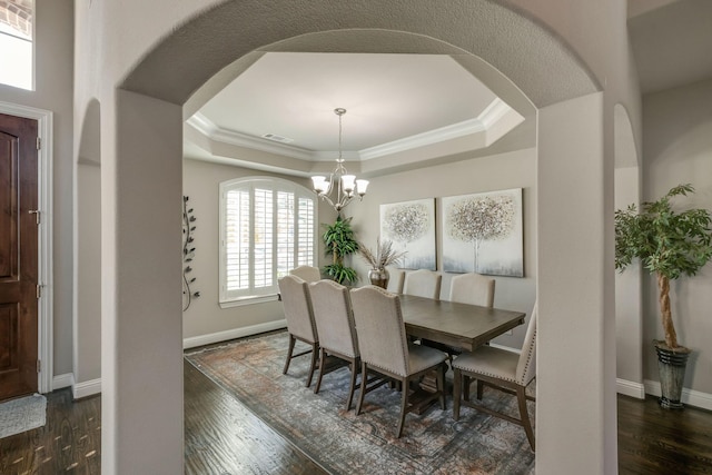 dining area with a raised ceiling, baseboards, and dark wood-type flooring