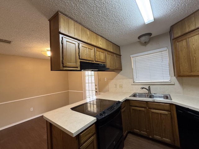 kitchen with visible vents, a peninsula, a sink, black appliances, and under cabinet range hood