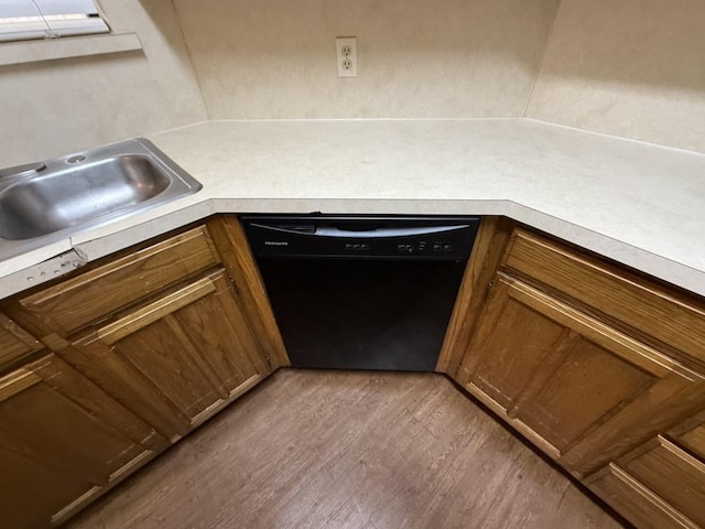 kitchen with dishwasher, light countertops, brown cabinets, wood finished floors, and a sink