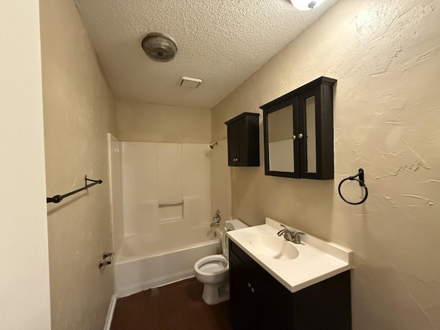 full bathroom featuring toilet, a textured ceiling, wood finished floors, tub / shower combination, and vanity