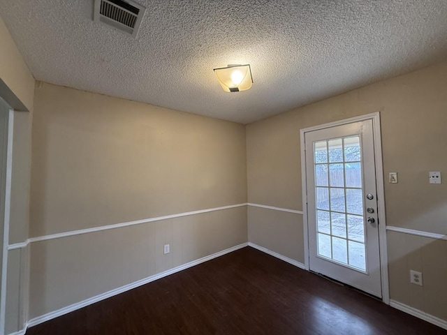 entryway featuring visible vents, a textured ceiling, and wood finished floors