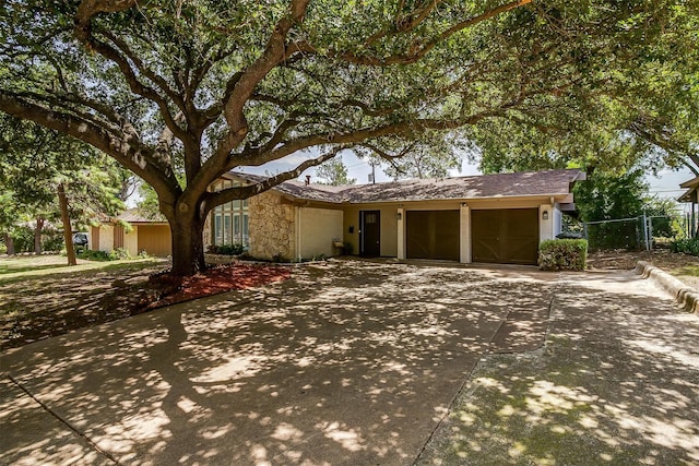 view of front facade with stone siding, concrete driveway, and an attached garage