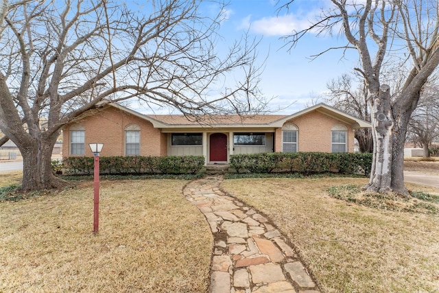 ranch-style house with a front yard and brick siding