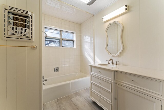 full bath with washtub / shower combination, vanity, a textured ceiling, and wood tiled floor