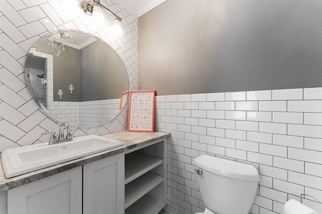 bathroom with toilet, tile walls, ornamental molding, and vanity