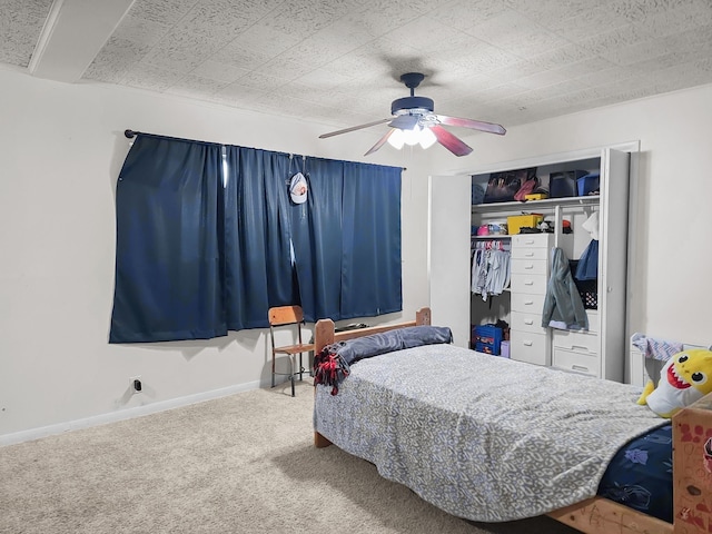 bedroom with a closet, baseboards, a ceiling fan, and carpet flooring