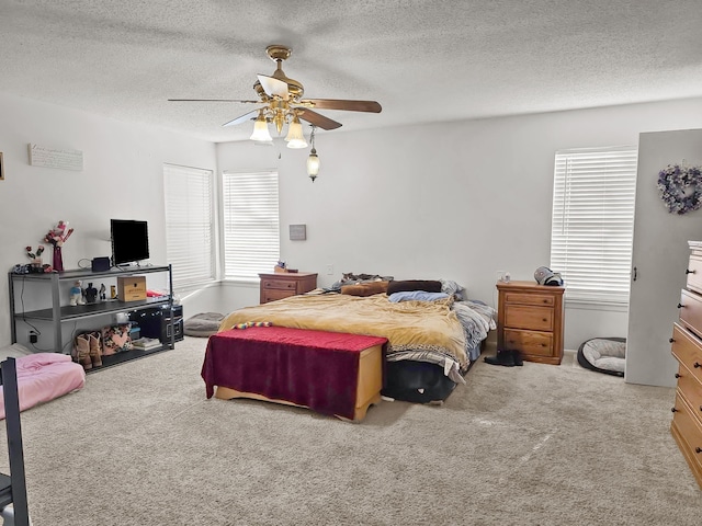 bedroom featuring multiple windows, a ceiling fan, and carpet