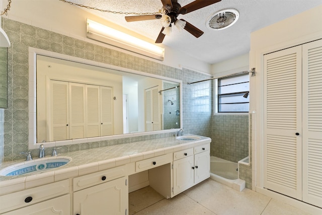 full bath featuring a sink, a closet, tiled shower / bath combo, and double vanity