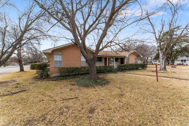 single story home with brick siding and a front yard