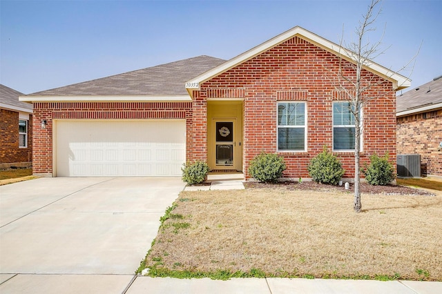 single story home featuring central air condition unit, an attached garage, brick siding, and driveway