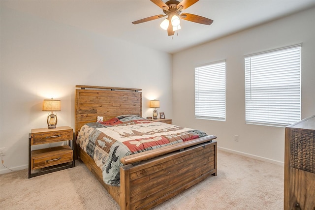 bedroom featuring light colored carpet, baseboards, and ceiling fan