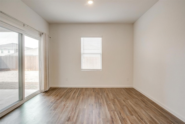 empty room with recessed lighting, light wood-style floors, and baseboards