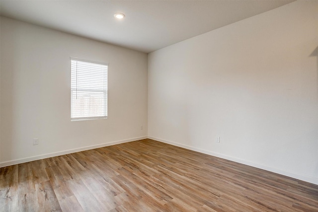 empty room featuring baseboards and wood finished floors