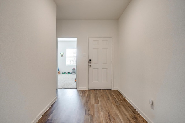 foyer entrance featuring wood finished floors and baseboards