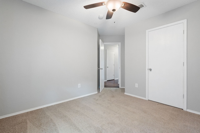 unfurnished bedroom featuring visible vents, baseboards, carpet, and a textured ceiling