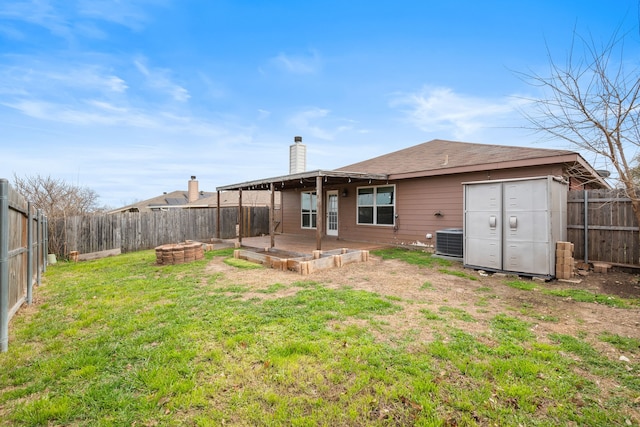 rear view of house with a yard, central AC, a fenced backyard, and a patio area