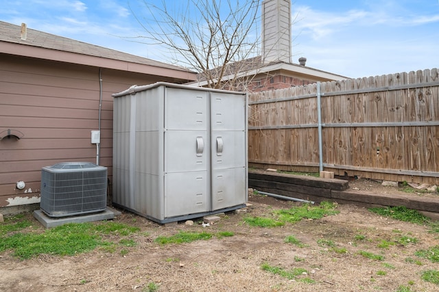 view of outdoor structure with fence and central AC