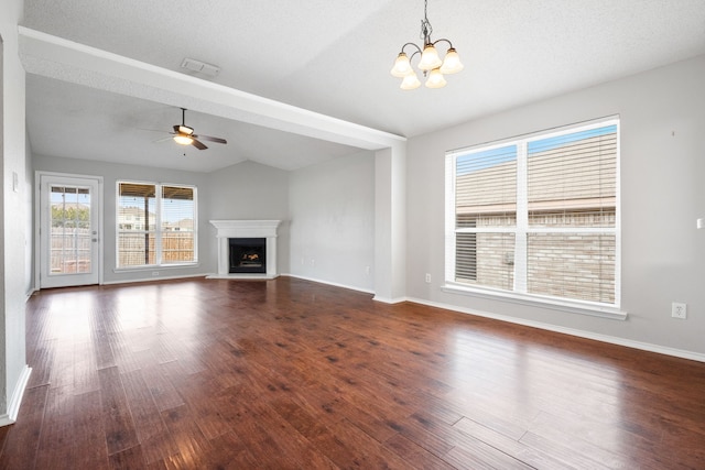 unfurnished living room with baseboards, a fireplace with raised hearth, dark wood finished floors, and ceiling fan with notable chandelier